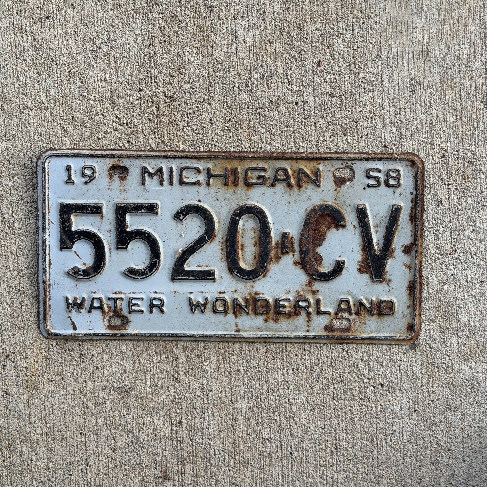 Photo of a 1958 Michigan Commercial License Plate Auto Tag Garage Decor Vintage 5520 CV with original patina