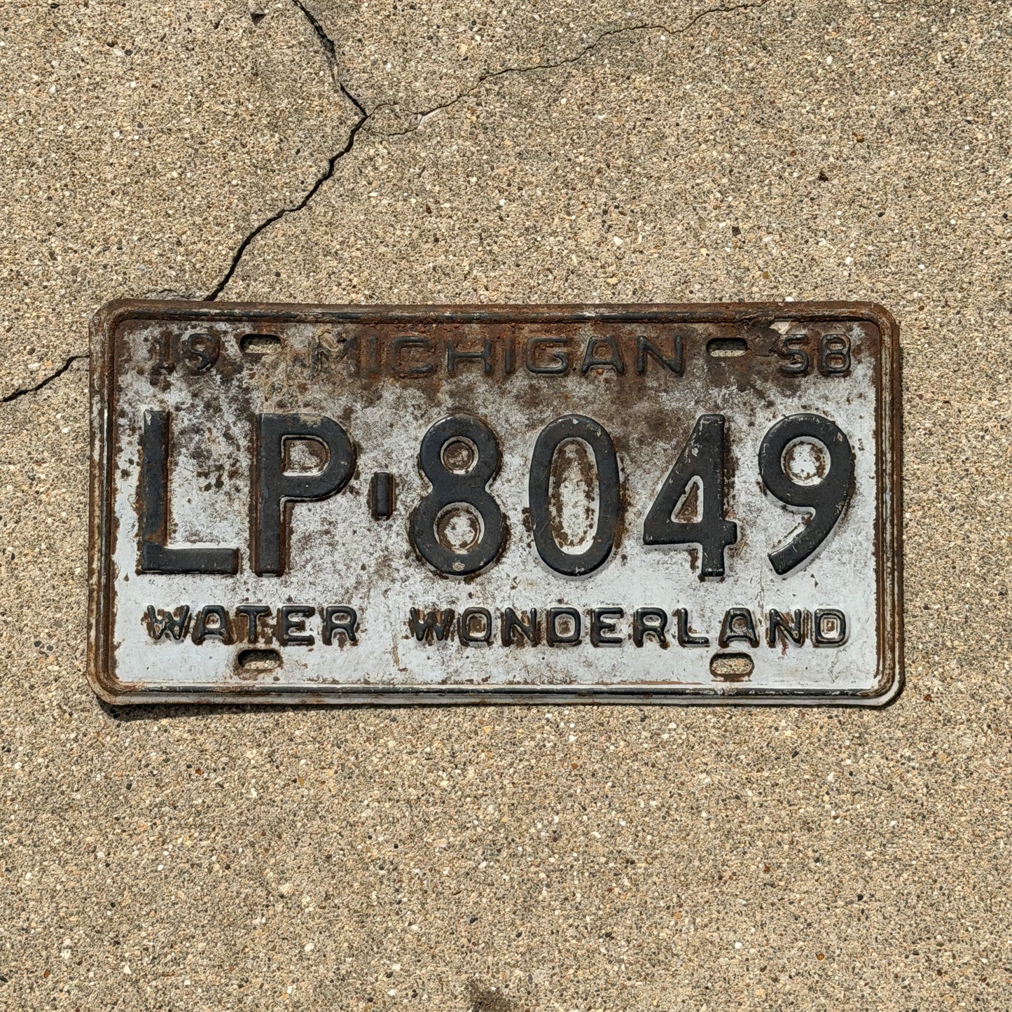Photo of a 1958 Michigan License Plate Auto Tag Garage Decor Vintage LP 8049 with original patina