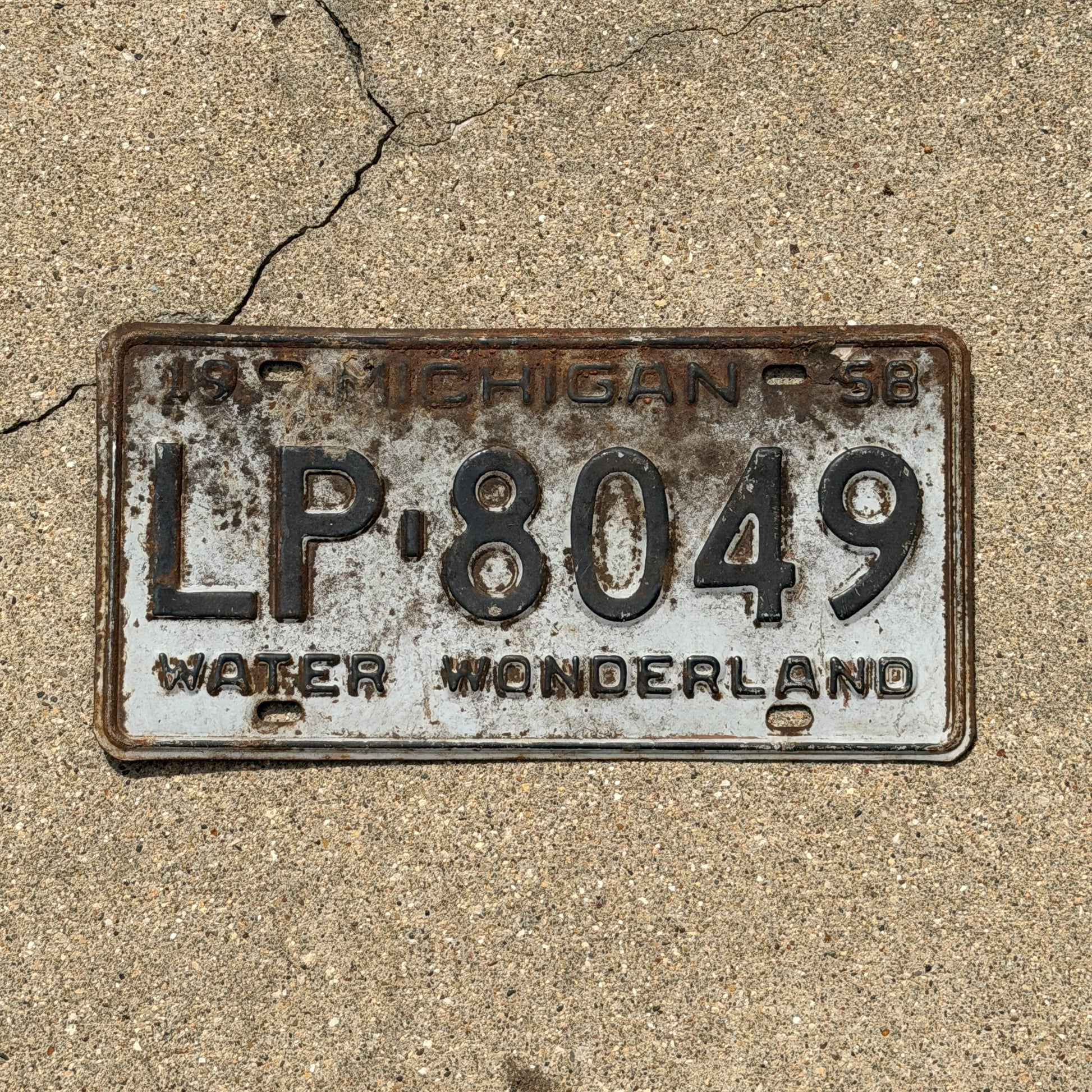 Photo of a 1958 Michigan License Plate Auto Tag Garage Decor Vintage LP 8049 with original patina