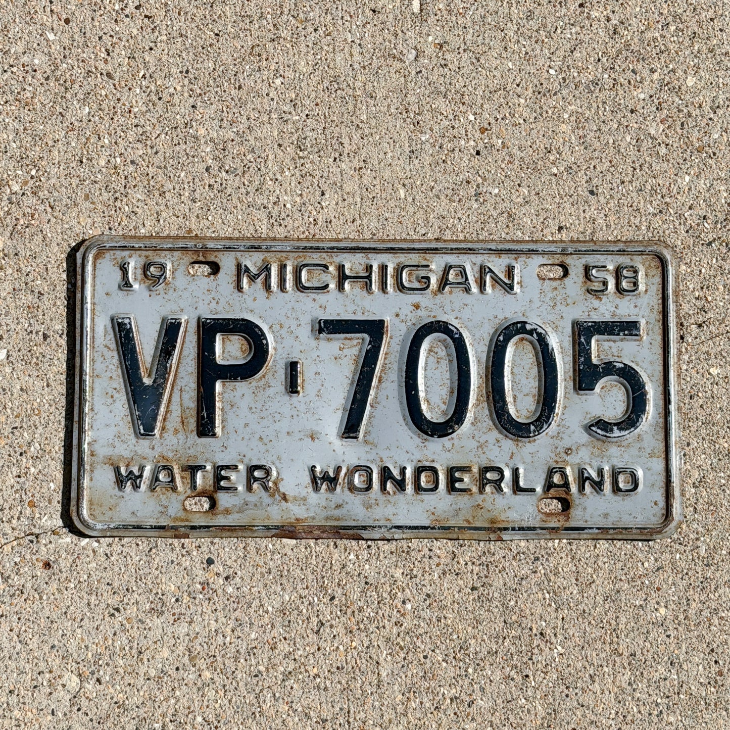 Photo of a 1958 Michigan License Plate Auto Tag Garage Decor Vintage VP 7005 with original patina
