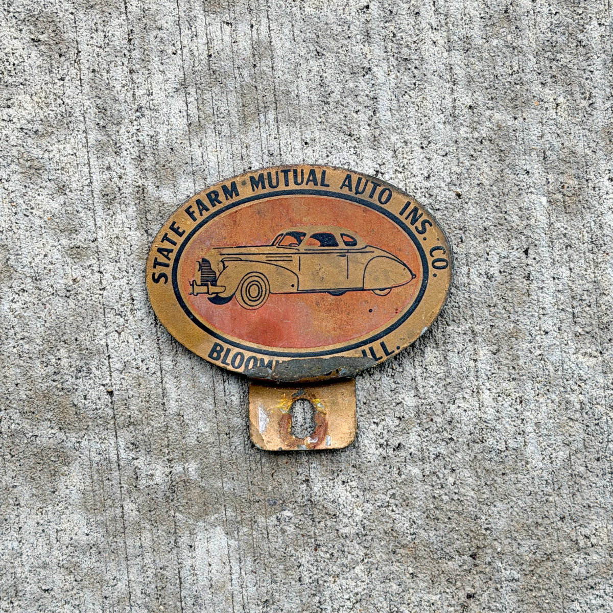 Photo of a 1960 Era Bloomington Illinois License Plate Topper Auto Tag Garage Decor Vintage State Farm Mutual Auto Insurance Company with original patina