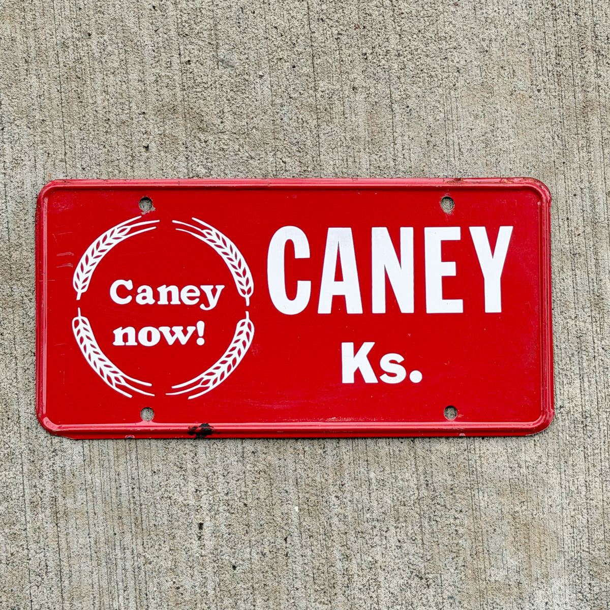 Photo of a 1960 Era Caney Kansas Booster License Plate Auto Tag Garage Decor Vintage with original patina