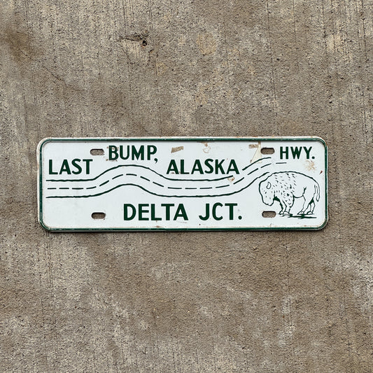 Photo of a 1960 Era Delta Junction Alaska License Plate Topper Auto Tag Garage Decor Vintage Last Bump Dalton Highway Bison with original patina