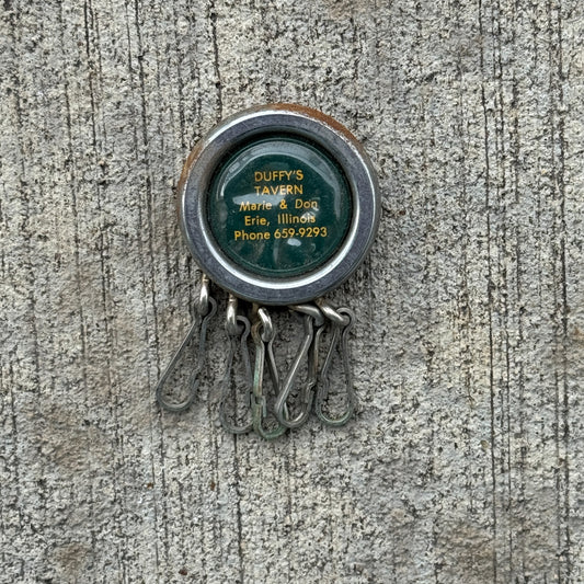 Photo of a 1960 Era Duffy's Tavern Erie Illinois Keychain Auto Tag Garage Decor Vintage Keychain Key Ring with original patina