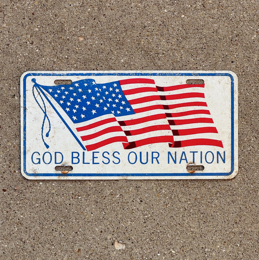 Photo of a 1960 Era God Bless Our Nation Booster License Plate Auto Tag Garage Decor Vintage Patriotic American Flag USA God Bless Our Nation with original patina