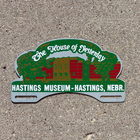Photo of a 1960 Era Hastings Nebraska License Plate Topper Auto Tag Garage Decor Vintage House of Yesterday Museum Neb. with original patina
