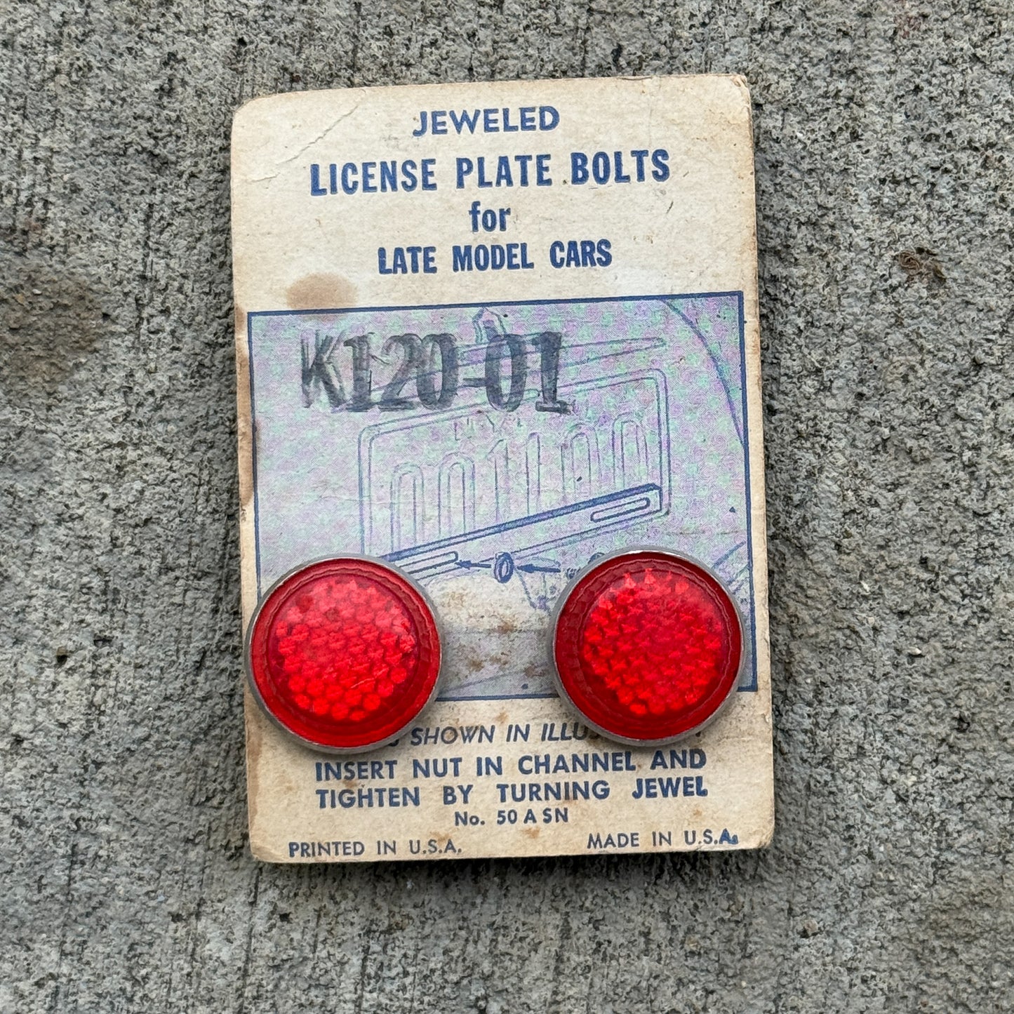 Photo of a 1960 Era Jeweled Auto Tag Garage Decor Vintage Bolts Plastic Reflectors New Old Stock with original patina