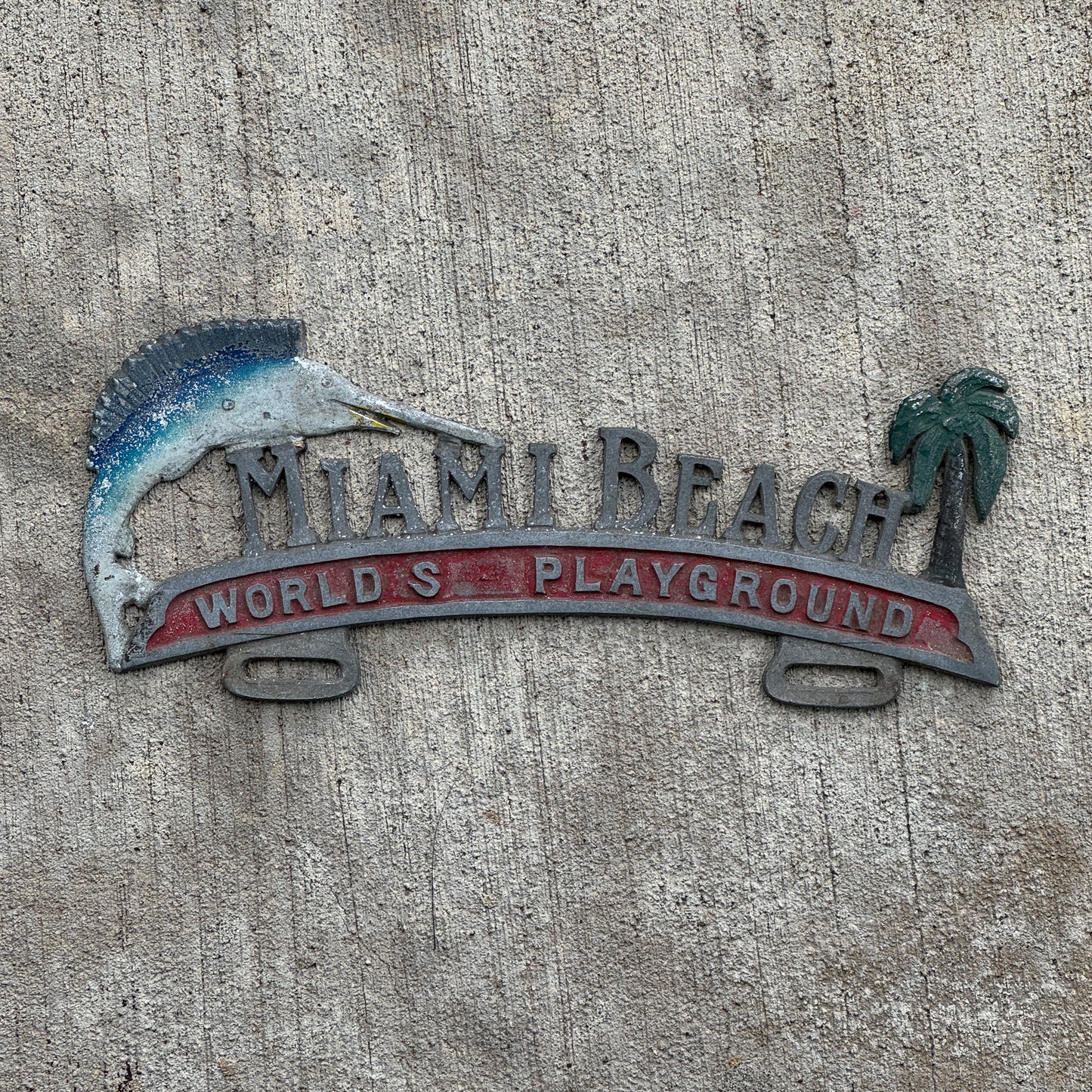 Photo of a 1960 Era Miami Beach Florida License Plate Topper Auto Tag Garage Decor Vintage World's Playground Cast Aluminum with original patina