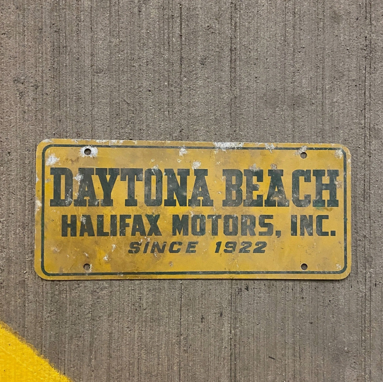 Photo of a 1960 Era North Carolina Booster License Plate Auto Tag Garage Decor Vintage Daytona Beach Halifax Motors NC with original patina