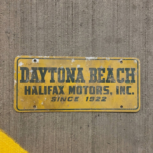 Photo of a 1960 Era North Carolina Booster License Plate Auto Tag Garage Decor Vintage Daytona Beach Halifax Motors NC with original patina