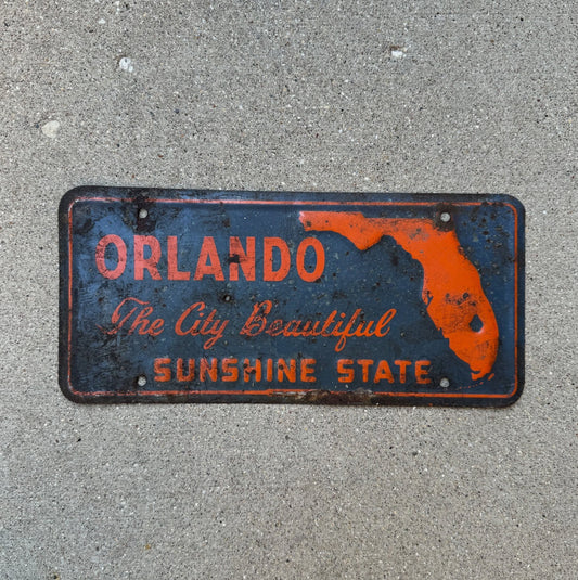 Photo of a 1960 Era Orlando Florida Booster License Plate Auto Tag Garage Decor Vintage Orange Blue Sunshine State with original patina