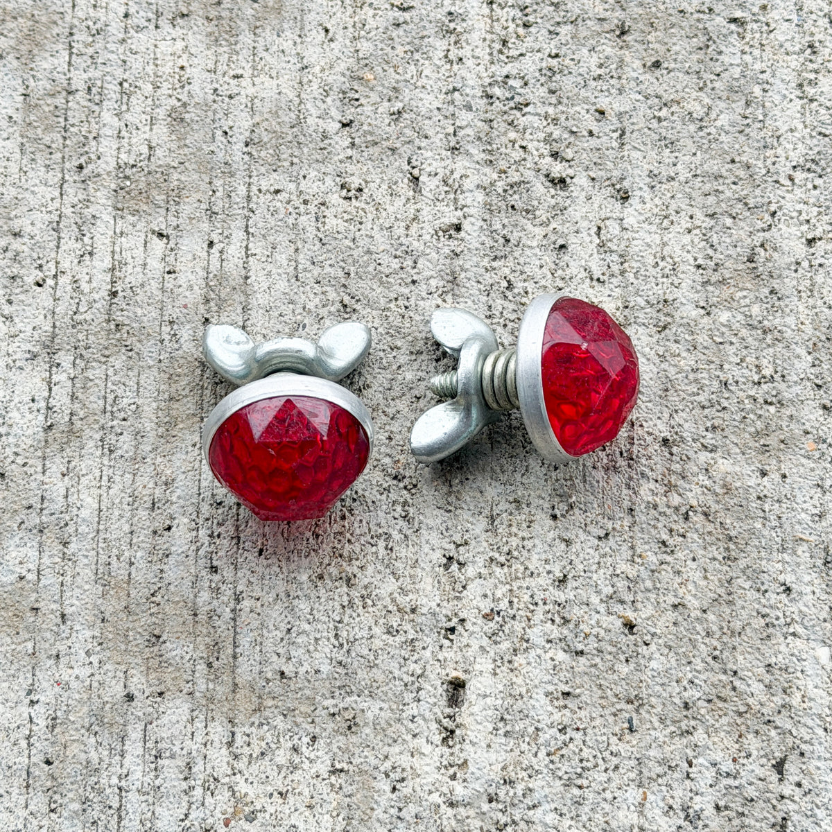 Photo of a 1960 Era Red Jewel Auto Tag Garage Decor Vintage Reflector Set Plastic Round Bike Motorcycle Car with original patina