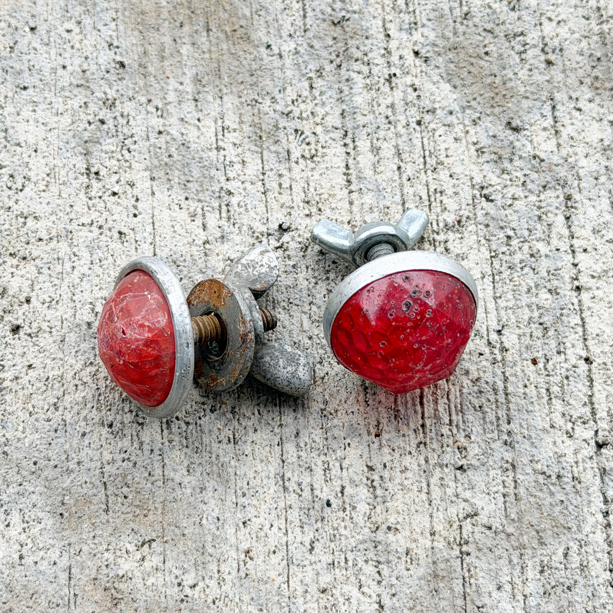 Photo of a 1960 Era Red Jewel Auto Tag Garage Decor Vintage Reflector Set Plastic Round Bike Motorcycle Car with original patina