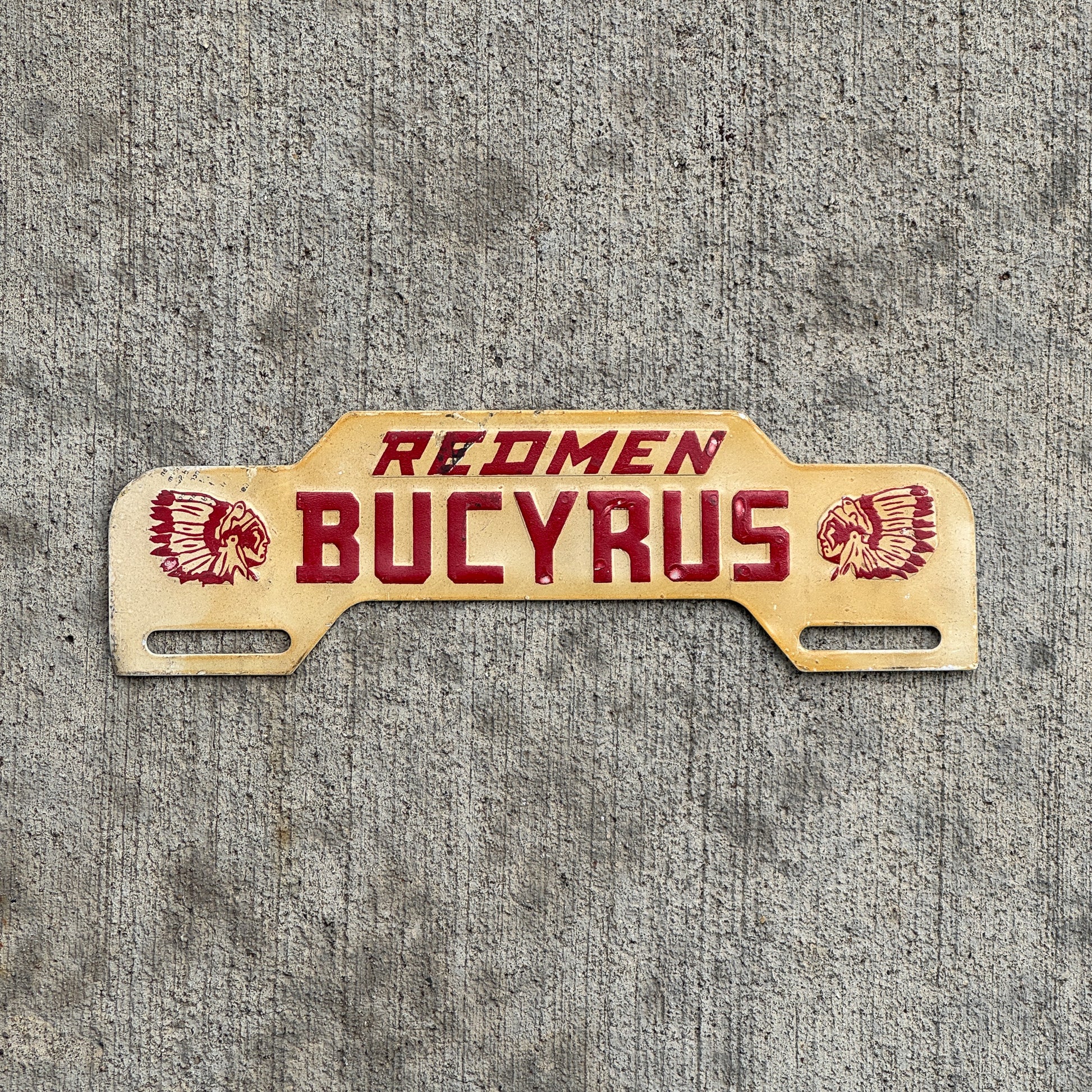 Photo of a 1960 Era Redmen Bucyrus Ohio License Plate Topper Auto Tag Garage Decor Vintage High School with original patina