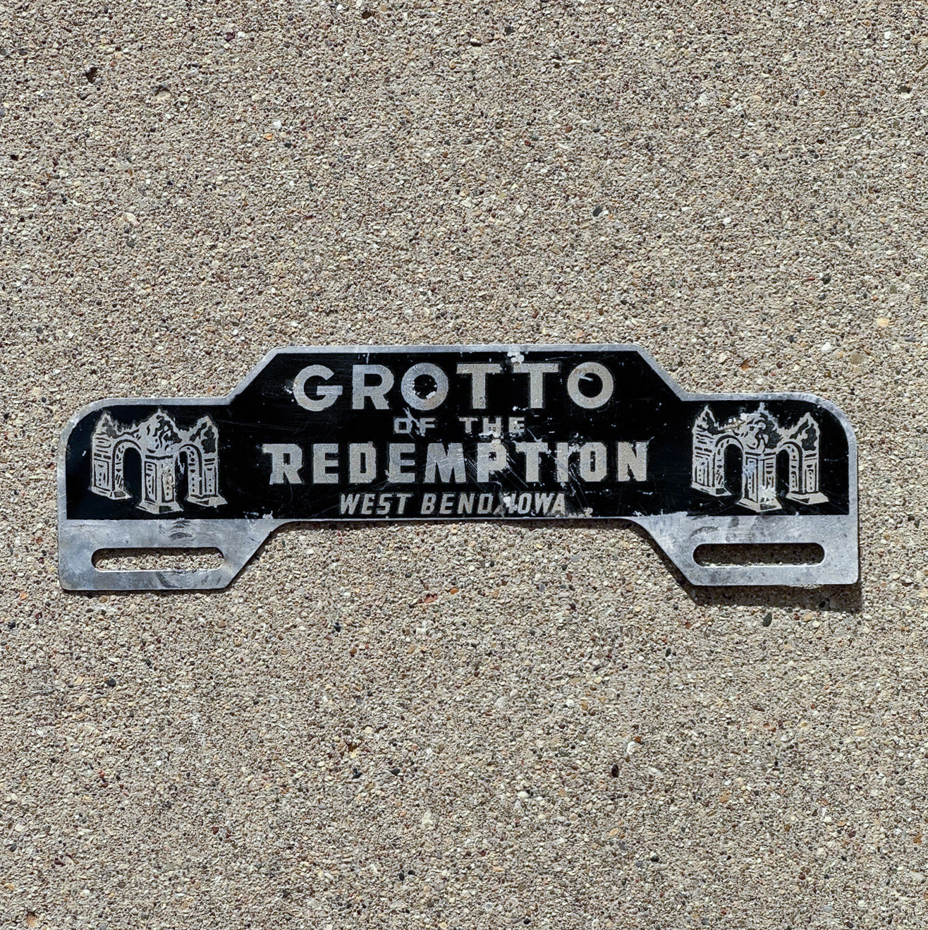 Photo of a 1960 Era West Bend Iowa License Plate Topper Auto Tag Garage Decor Vintage Vintage Grotto of the Redemption with original patina