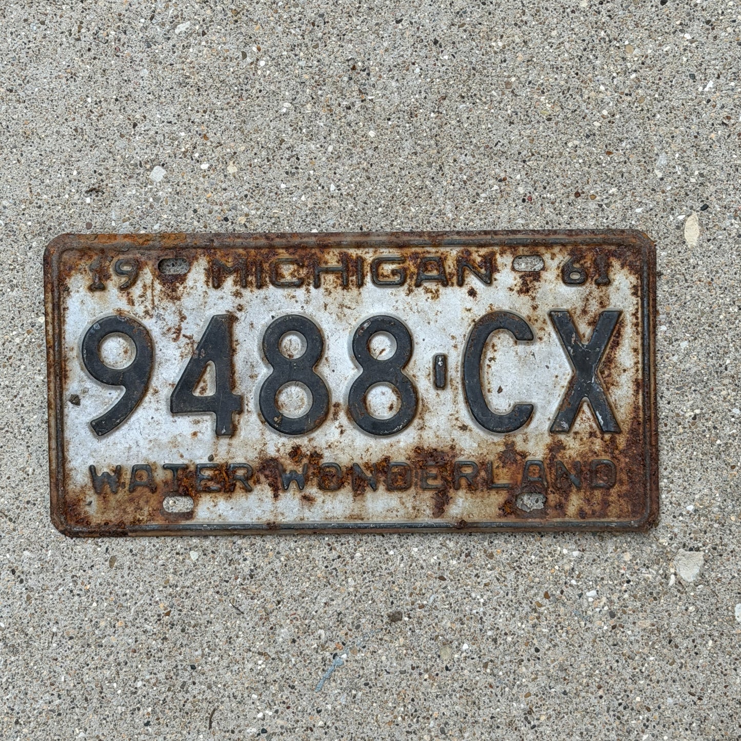 Photo of a 1961 Michigan Commercial License Plate Auto Tag Garage Decor Vintage 9488 CX with original patina