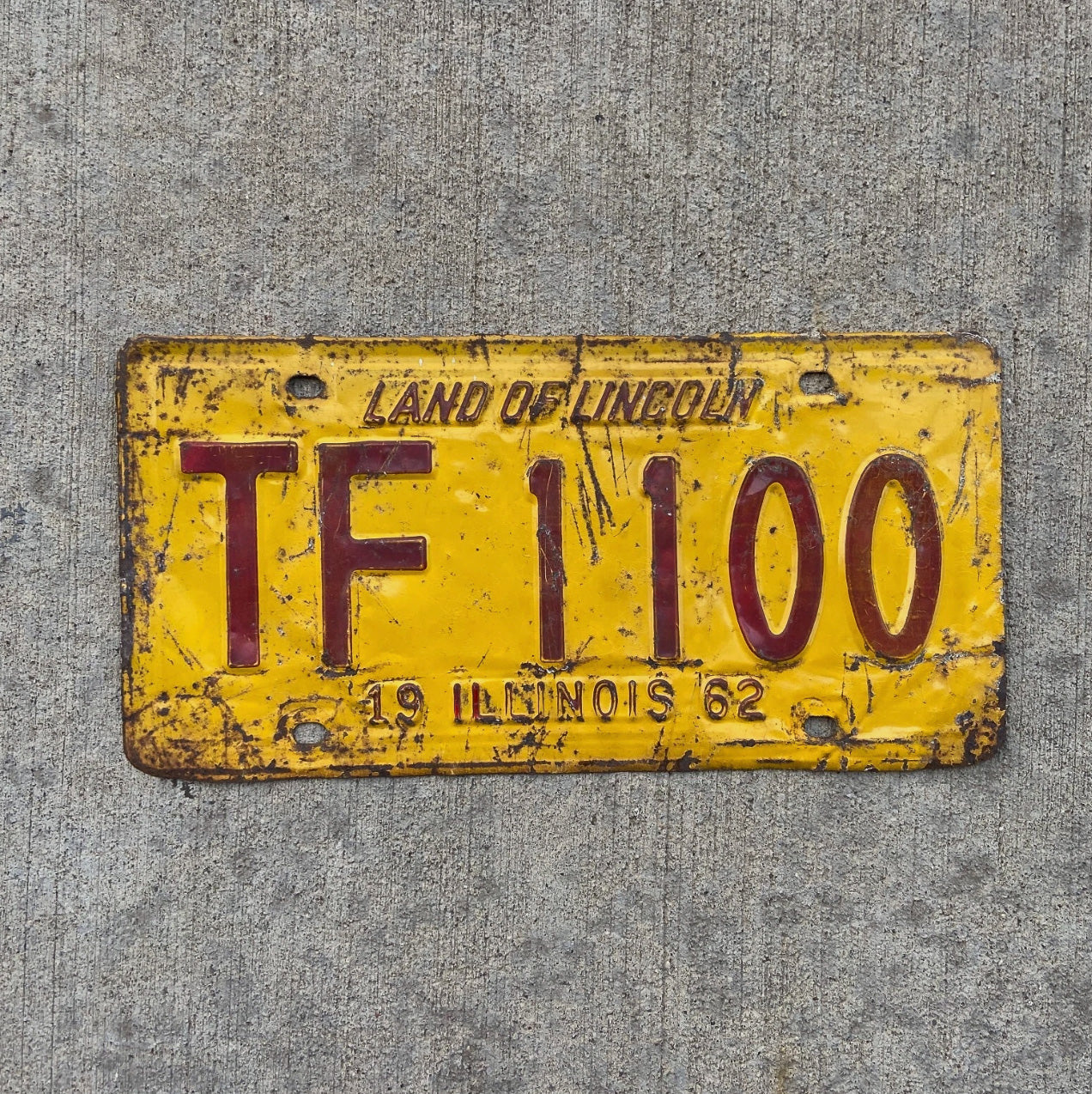 Photo of a 1962 Illinois Truck Mileage Tax License Plate Auto Tag Garage Decor Vintage TF 1100 with original patina