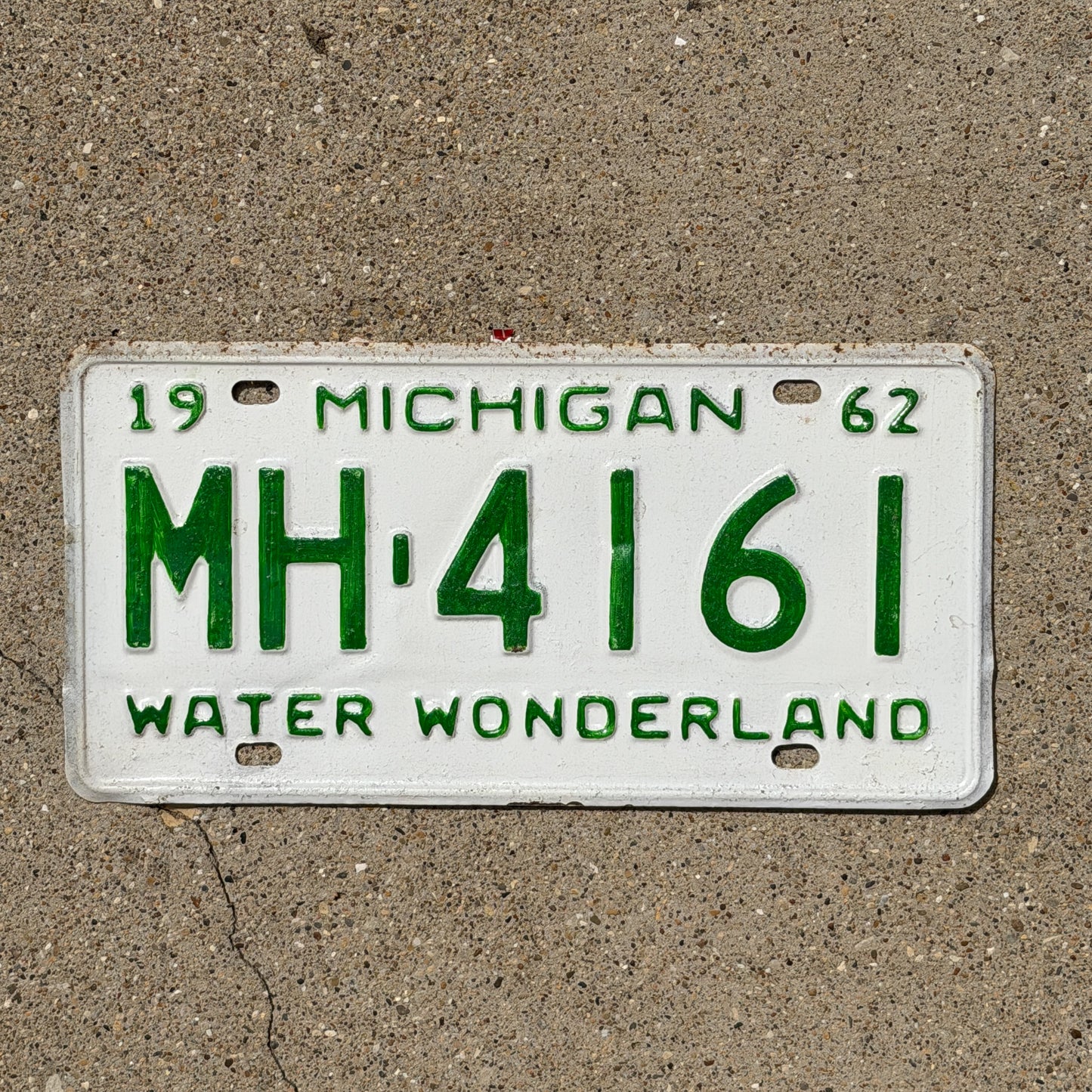 Photo of a 1962 Michigan License Plate Auto Tag Garage Decor Vintage MH 4161 with original patina