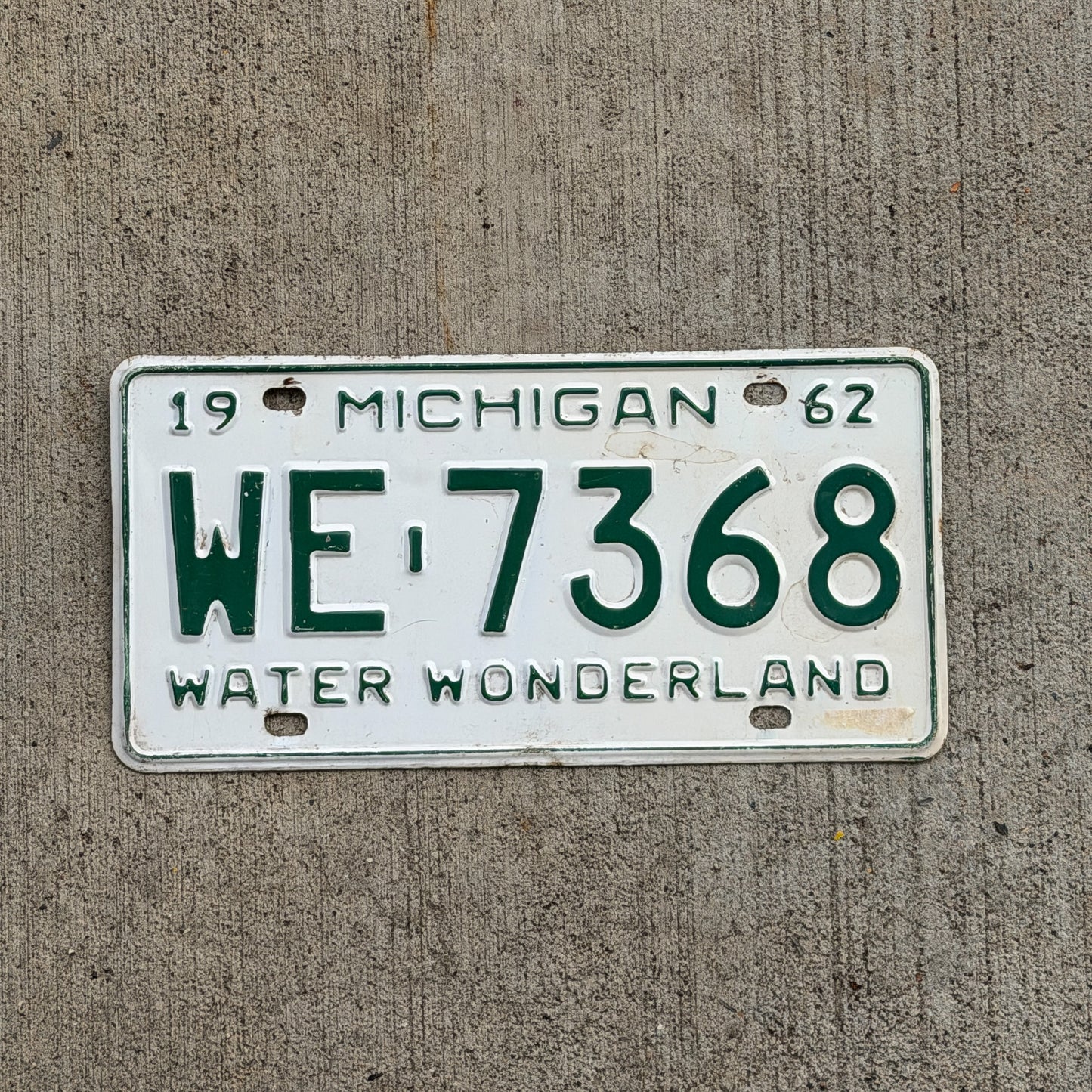 Photo of a 1962 Michigan License Plate Auto Tag Garage Decor Vintage WE 7368 with original patina
