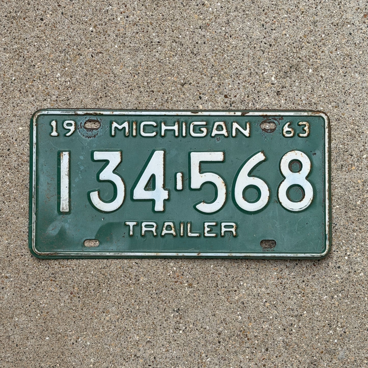 Photo of a 1963 Michigan Trailer License Plate Auto Tag Garage Decor Vintage 134 568 with original patina