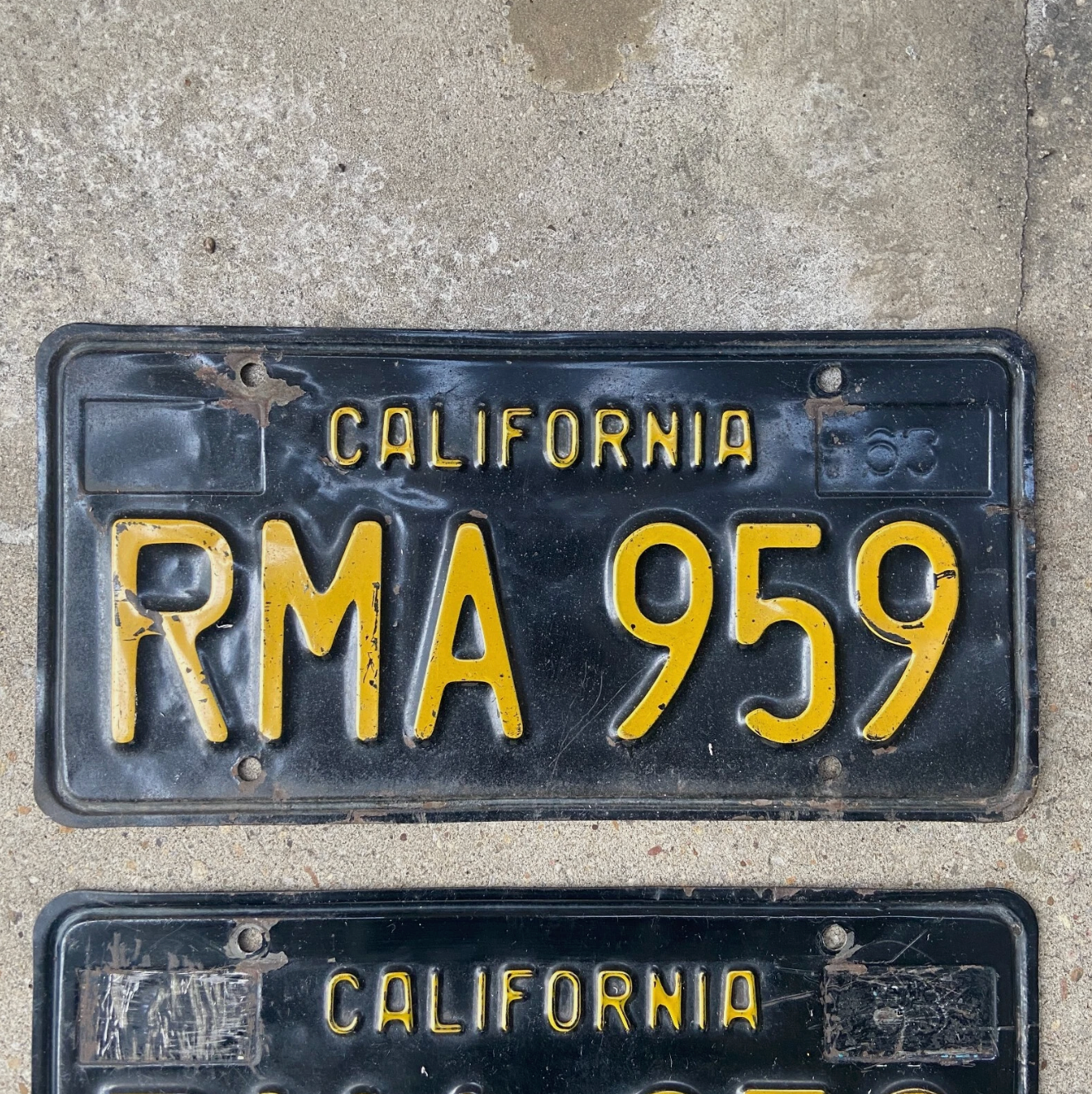 1963 California License plate number RMA959 on a concrete background.