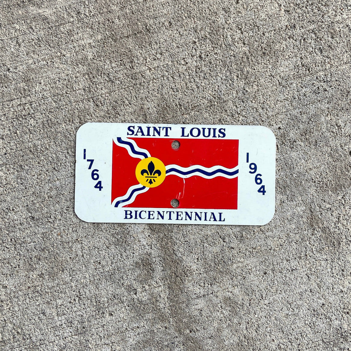 Photo of a 1964 Missouri Motorcycle Booster License Plate Auto Tag Garage Decor Vintage SAINT LOUIS BICENTENNIAL with original patina