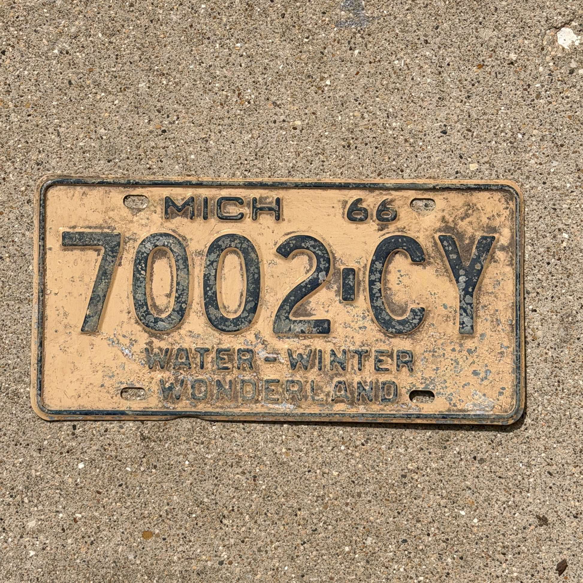 Photo of a 1966 Michigan Commercial License Plate Auto Tag Garage Decor Vintage 7002 CY with original patina