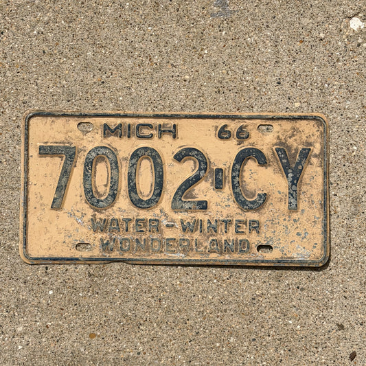 Photo of a 1966 Michigan Commercial License Plate Auto Tag Garage Decor Vintage 7002 CY with original patina