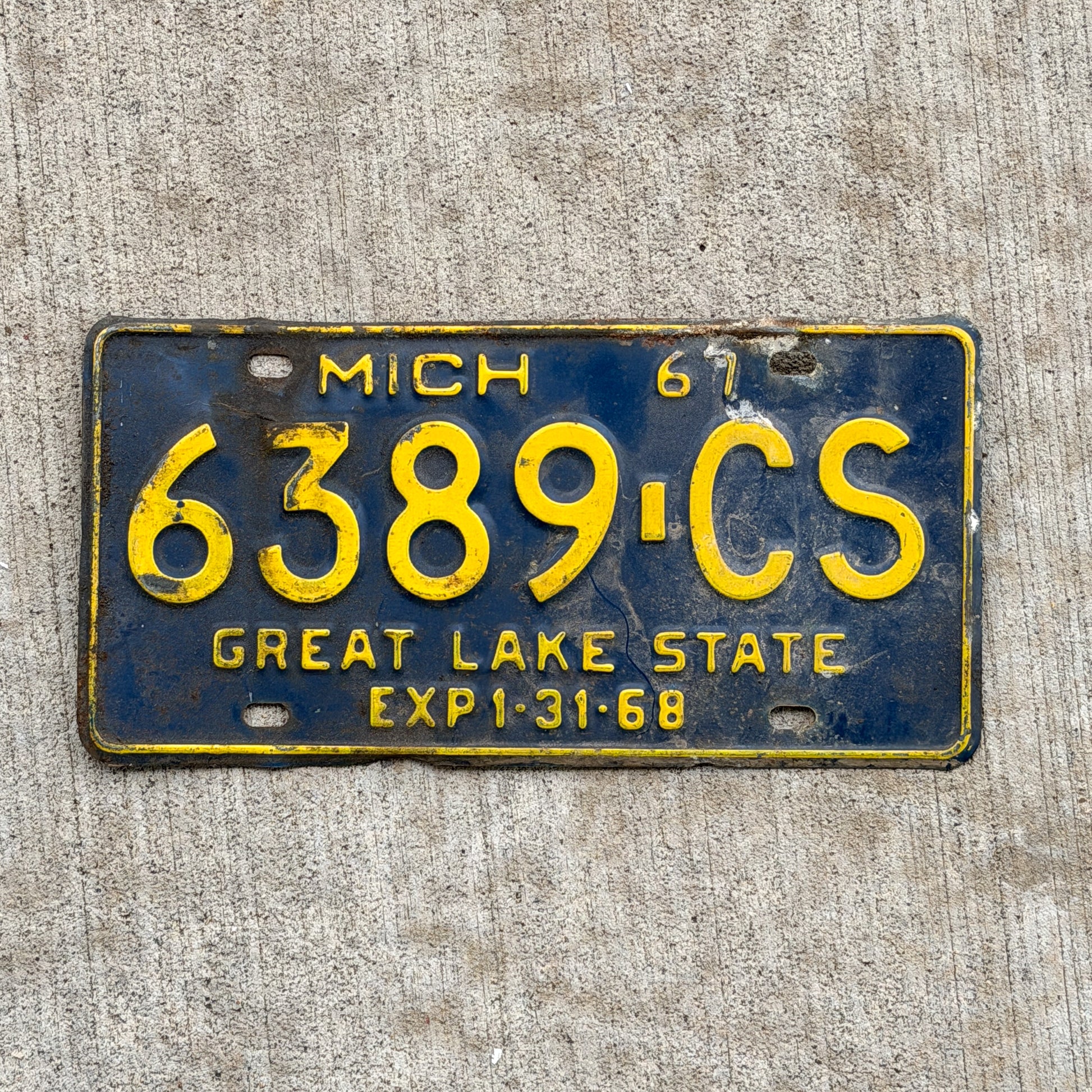 Photo of a 1967 Michigan Commercial License Plate Auto Tag Garage Decor Vintage 6389 CS with original patina