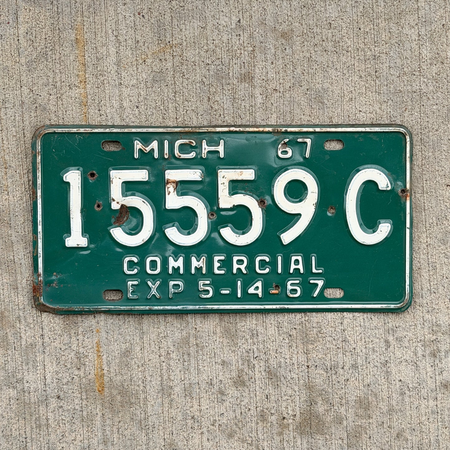 Photo of a 1967 Michigan Commercial License Plate Auto Tag Garage Decor Vintage Half Year Repeat Repeating 15559 C with original patina