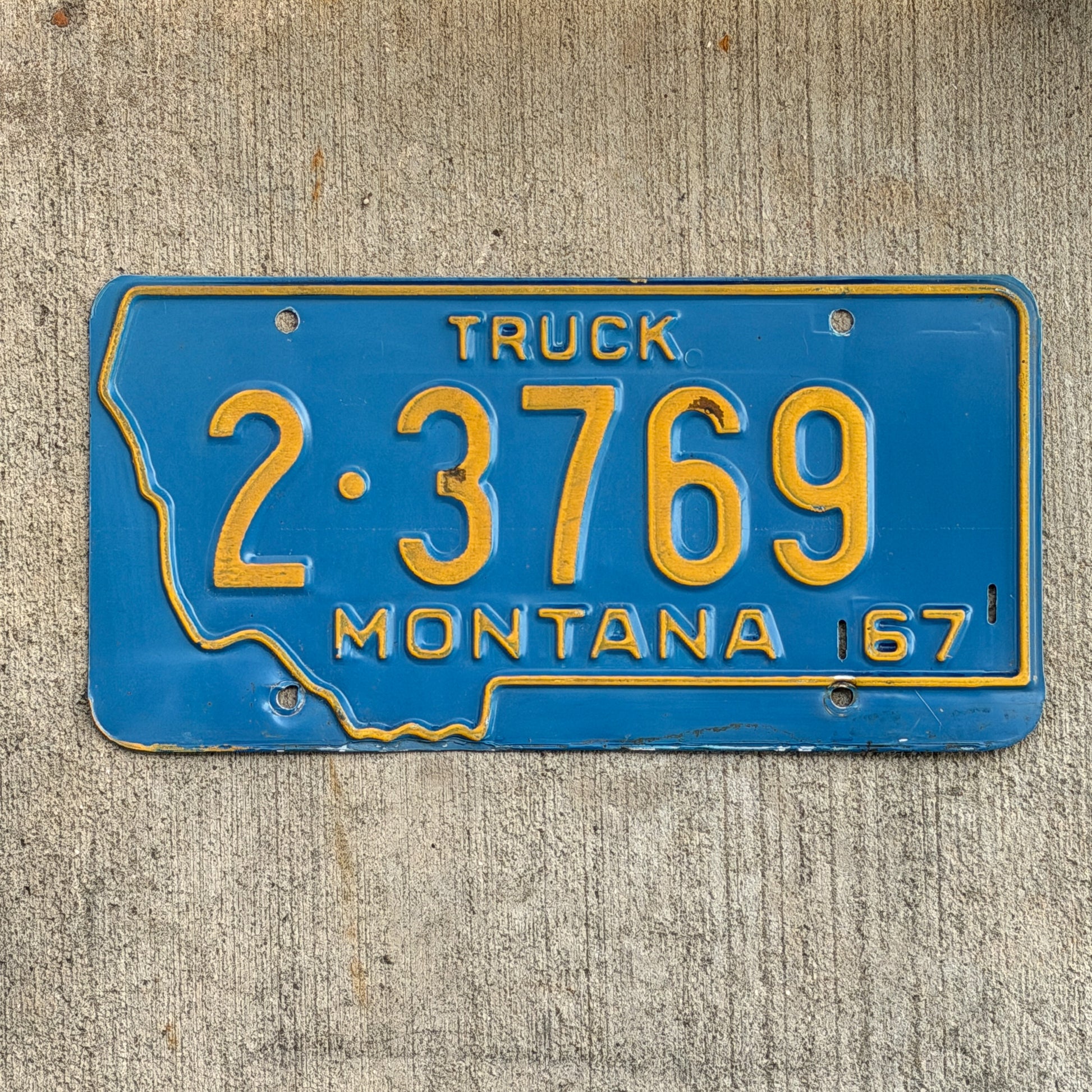 Photo of a 1967 Montana Truck License Plate Auto Tag Garage Decor Vintage State Shape 2 3769 with original patina