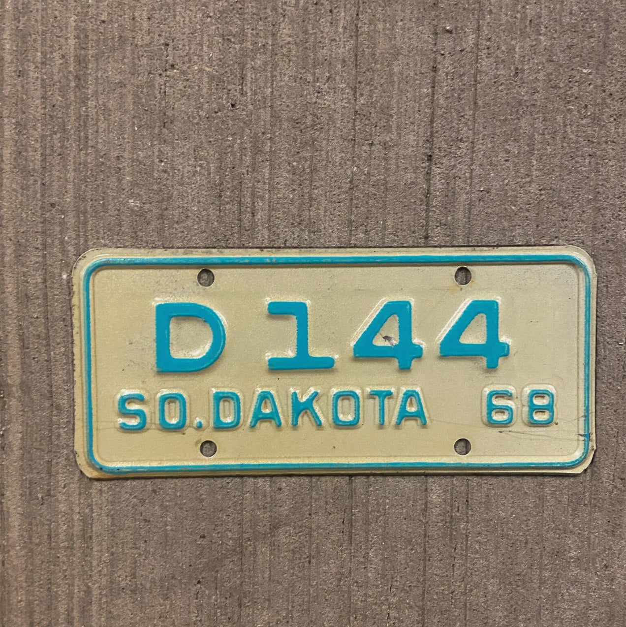 Photo of a 1968 South Dakota Motorcycle Dealer License Plate Auto Tag Garage Decor Vintage D 144 with original patina