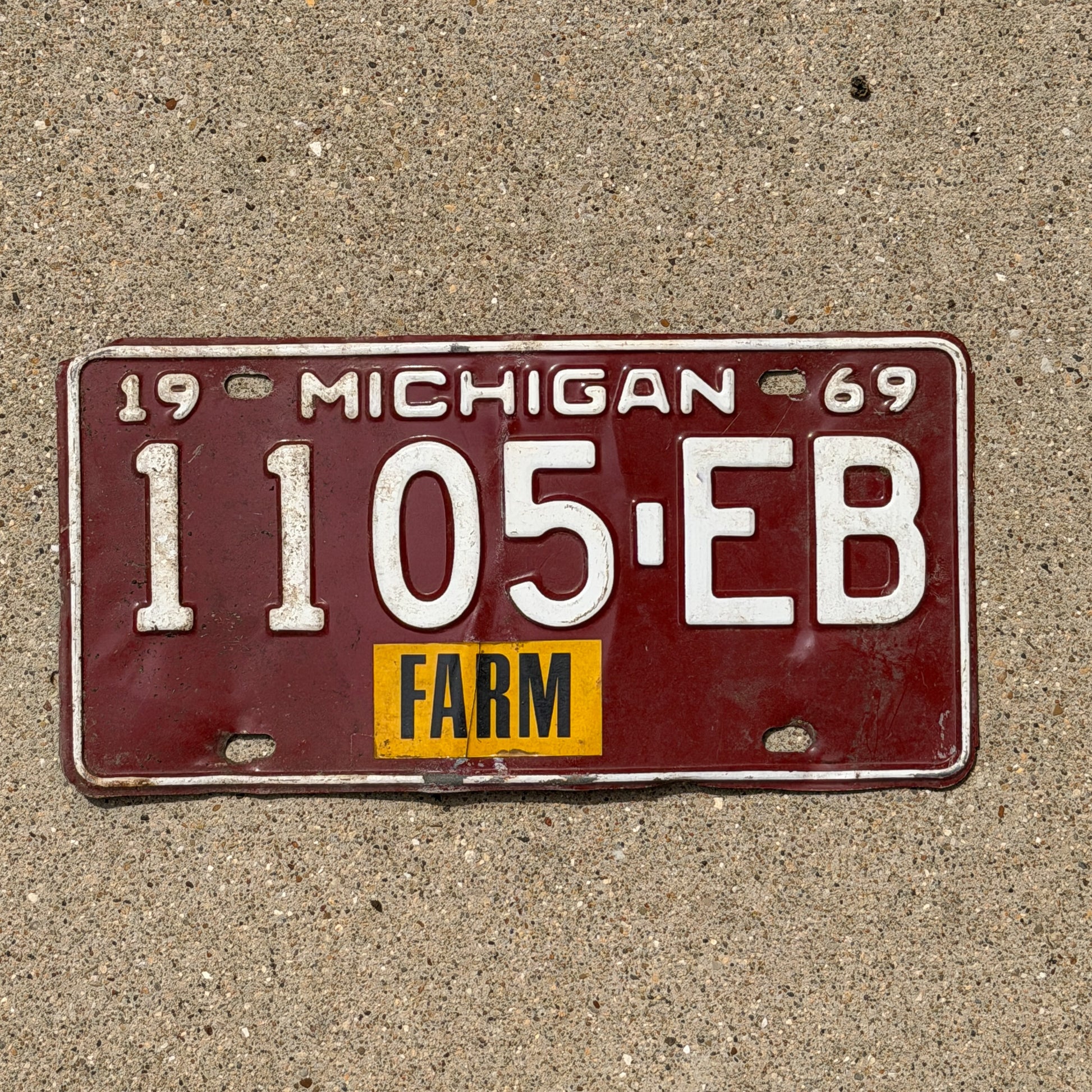 Photo of a 1969 Michigan Farm License Plate Auto Tag Garage Decor Vintage 1105 EB with original patina