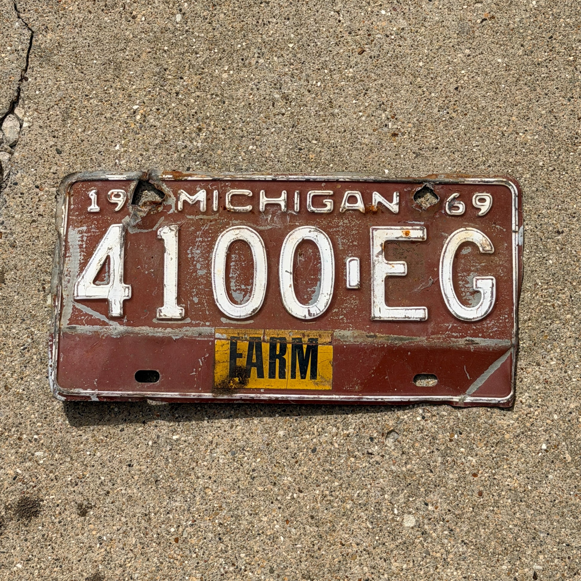 Photo of a 1969 Michigan Farm License Plate Auto Tag Garage Decor Vintage 4100 EG with original patina