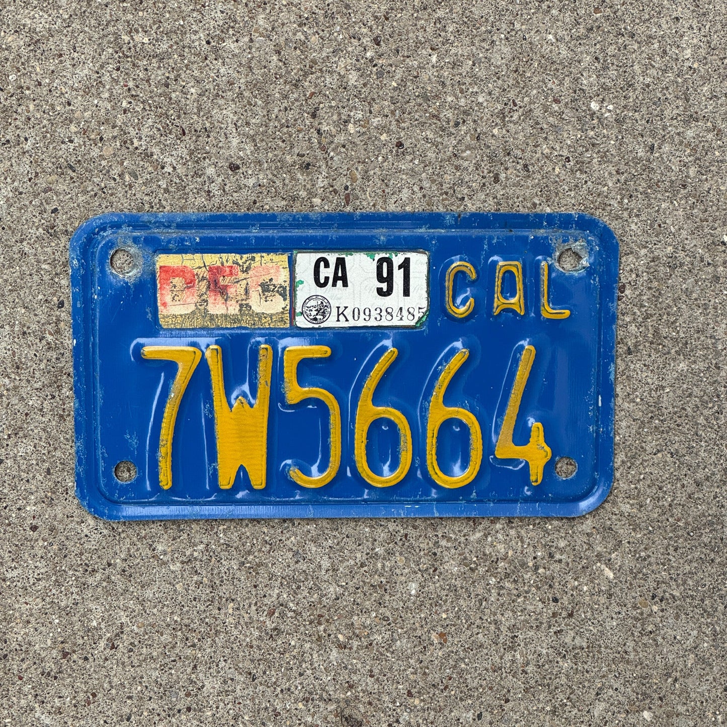 Photo of a 1970 1991 California Motorcycle License Plate Auto Tag Garage Decor Vintage 7W5664 with original patina