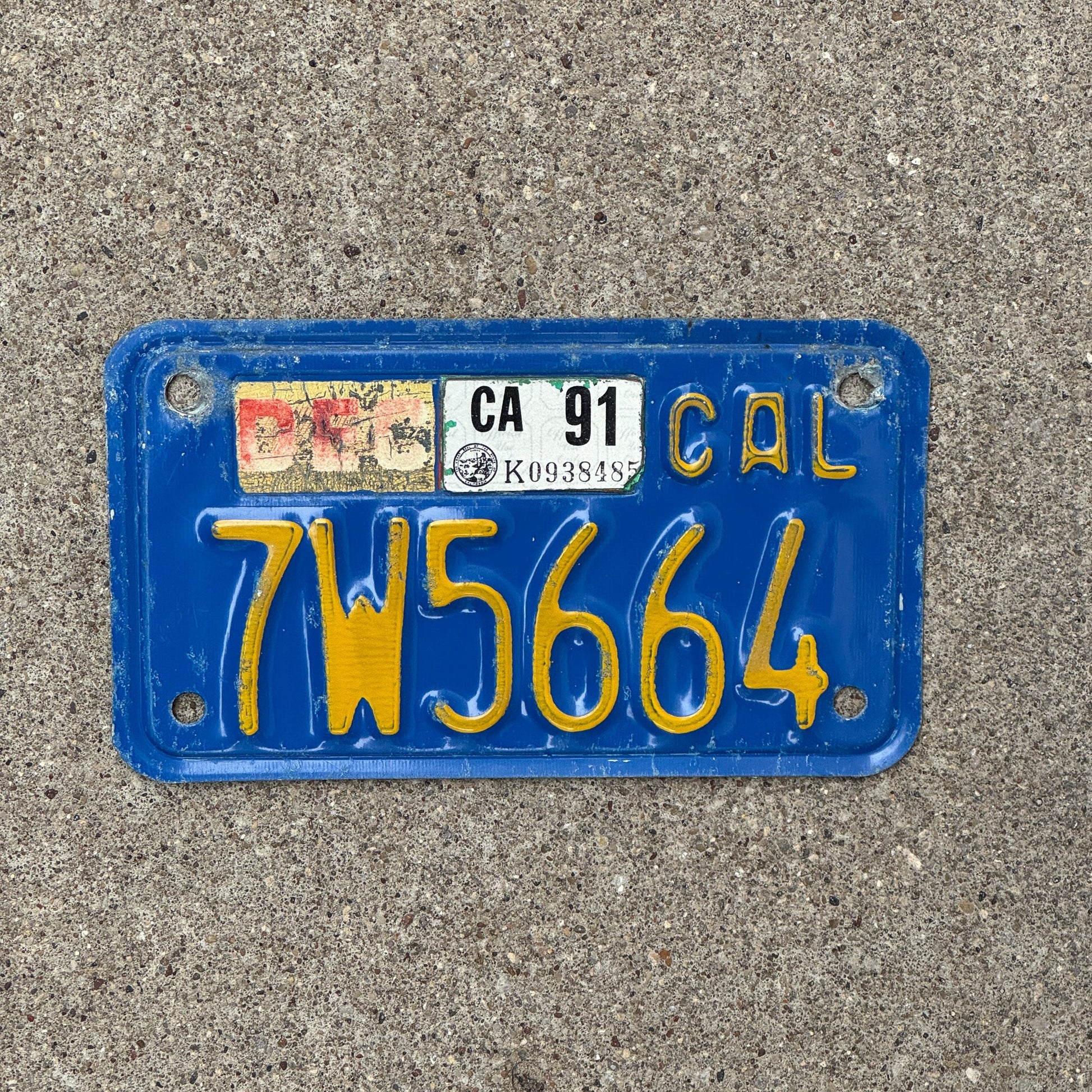 Photo of a 1970 1991 California Motorcycle License Plate Auto Tag Garage Decor Vintage 7W5664 with original patina