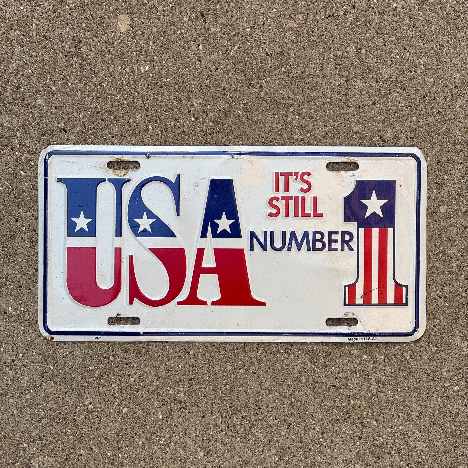 Photo of a 1970 Era Booster License Plate Auto Tag Garage Decor Vintage Metal USA It's Still Number 1 with original patina