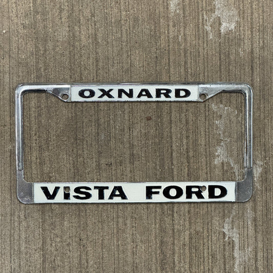 Photo of a 1970 Era California License Plate Frame Auto Tag Garage Decor Vintage Oxnard Metal Vista Ford with original patina