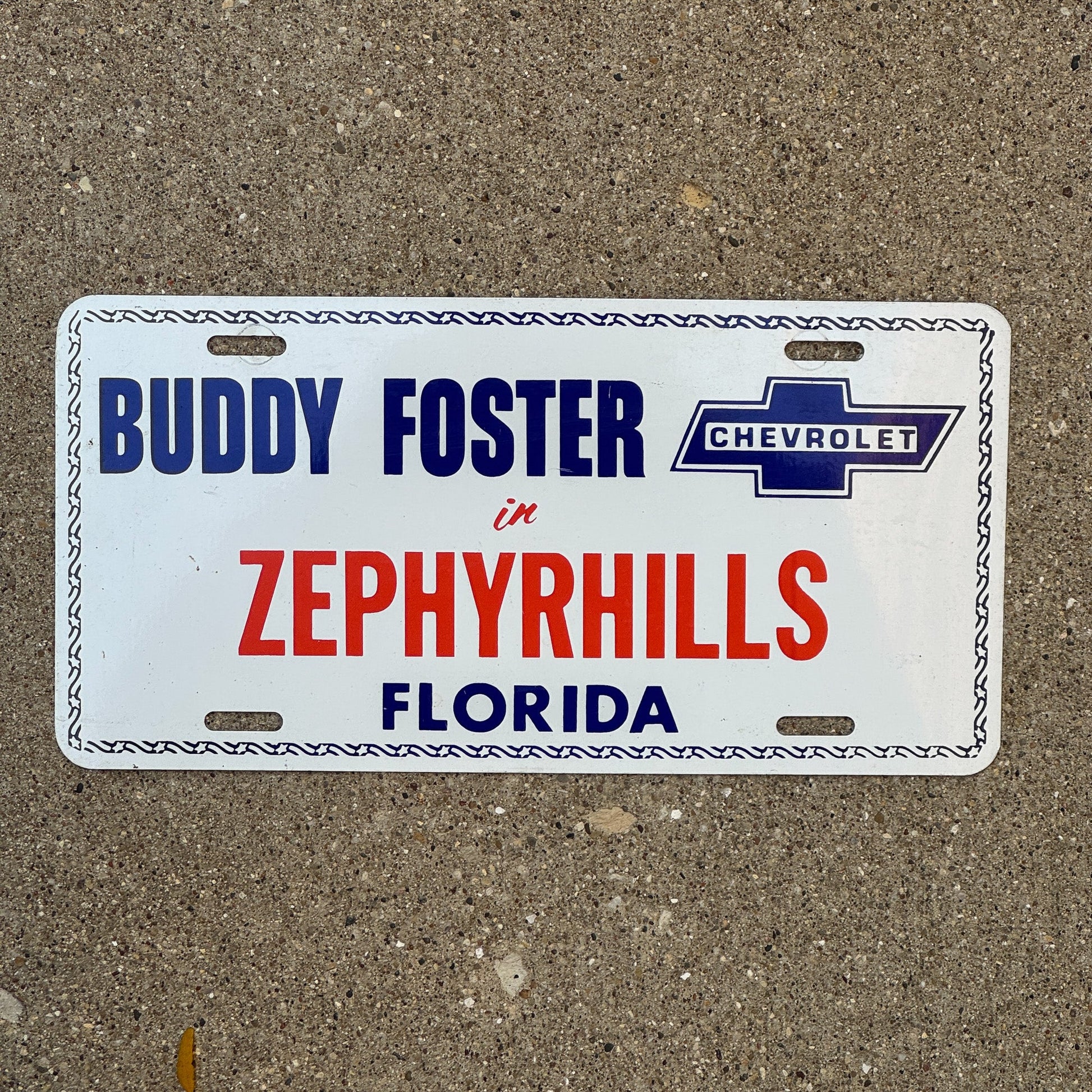 Photo of a 1970 Era Florida Booster License Plate Auto Tag Garage Decor Vintage Zephyrhills FL Metal Buddy Foster Chevrolet with original patina