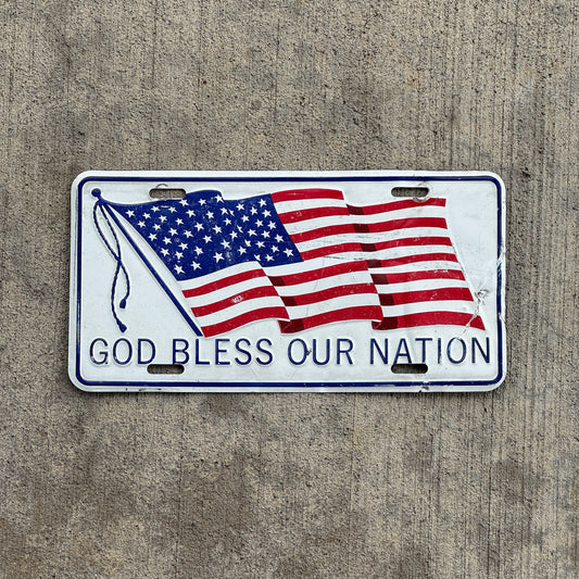 Photo of a 1970 Era God Bless Our Nation Booster License Plate Auto Tag Garage Decor Vintage Patriotic Metal with original patina
