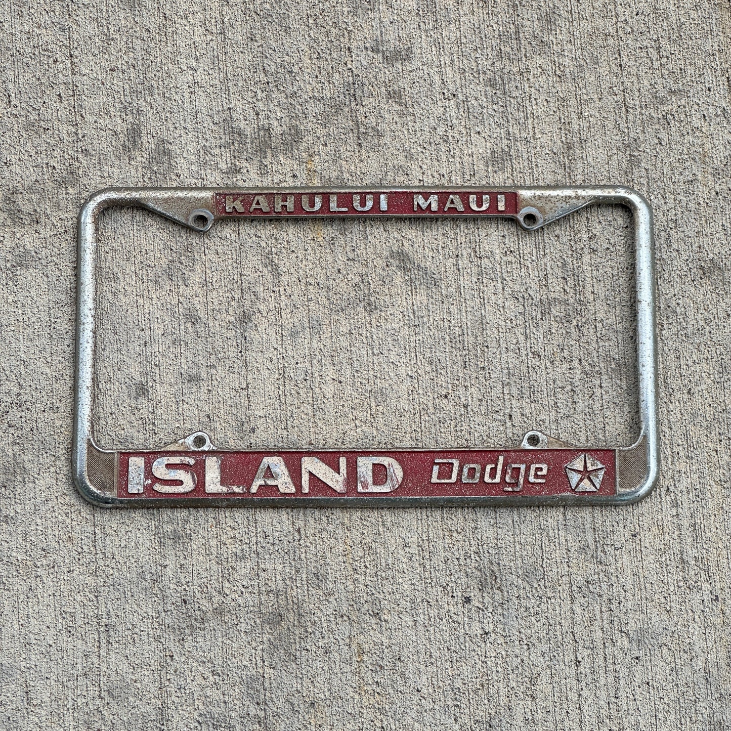 Photo of a 1970 Era Kahului Maui Hawaii License Plate Frame Auto Tag Garage Decor Vintage Island Dodge Dealer with original patina