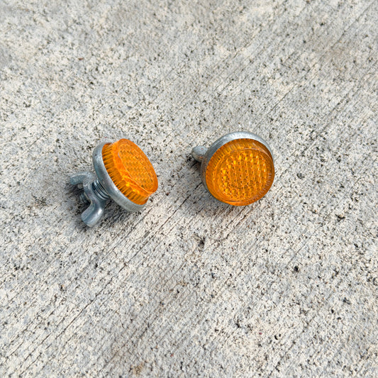 Photo of a 1970 Era Orange Jewel License Plate Auto Tag Garage Decor Vintage Reflector Set Plastic Amber Round Bike Car Motorcycle with original patina