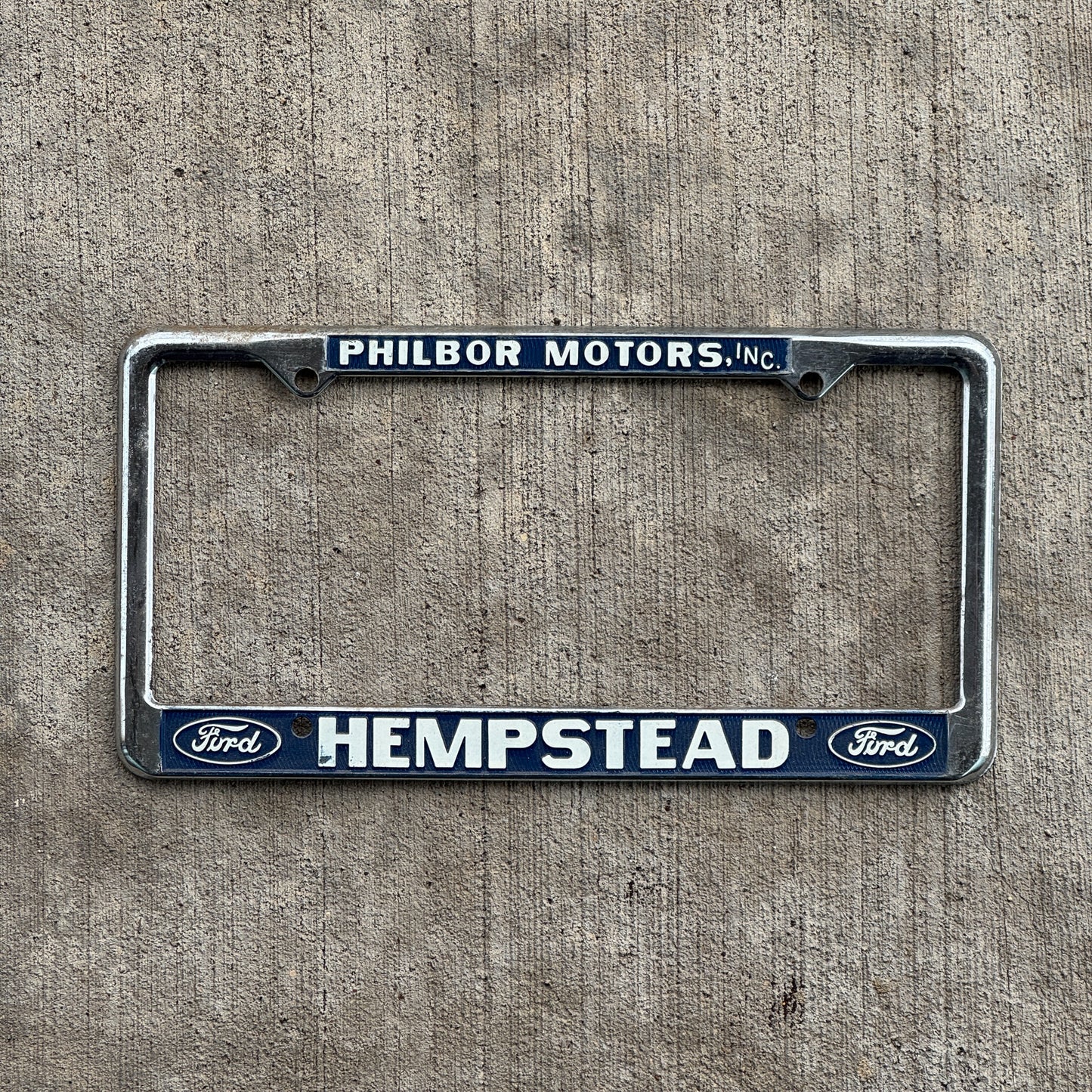 Photo of a 1970 Era Philbor Motors Hempstead New York License Plate Frame Auto Tag Garage Decor Vintage Ford Dealer with original patina