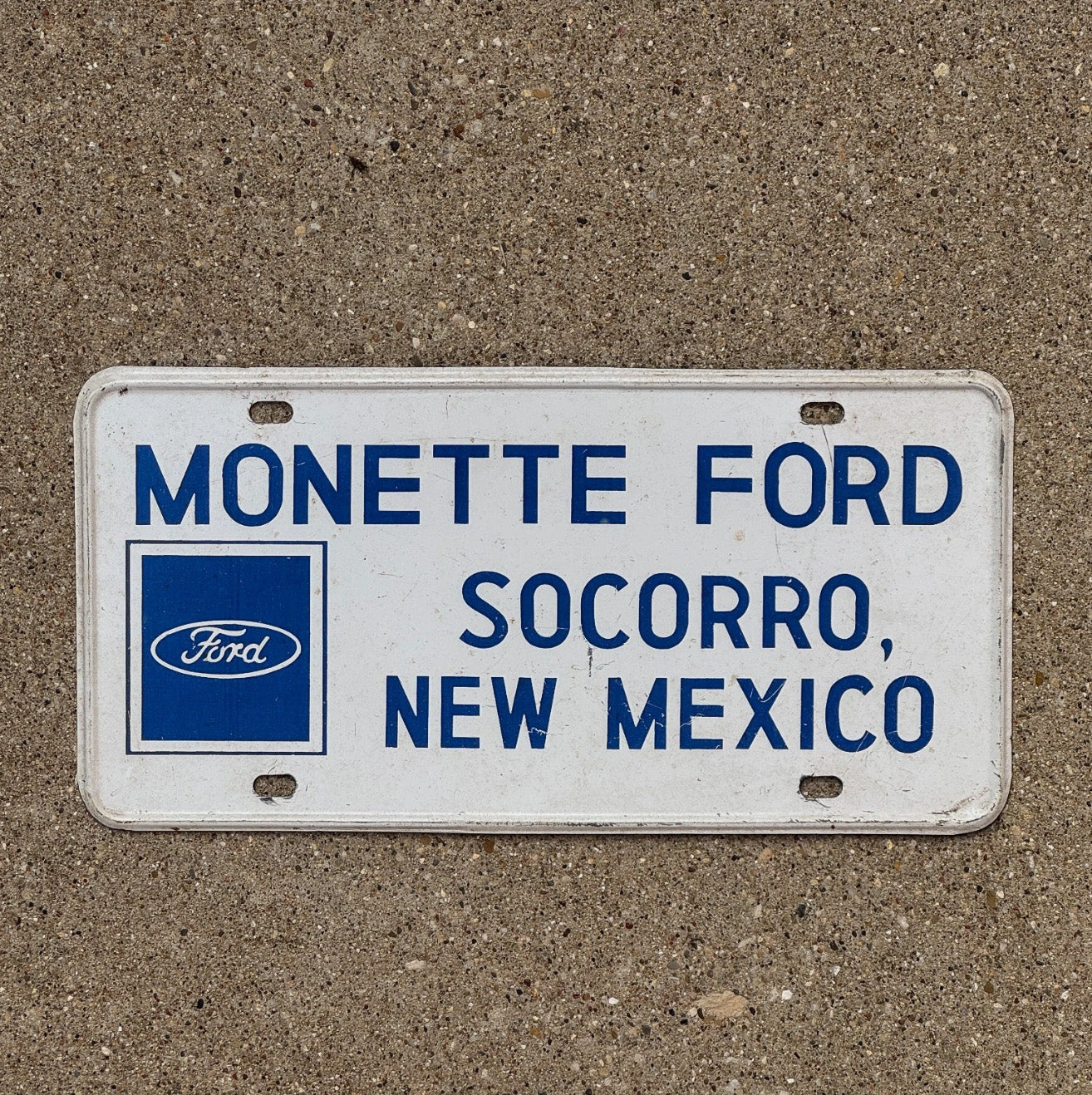 Photo of a 1970 Era Socorro New Mexico Booster License Plate Auto Tag Garage Decor Vintage Dealer Metal Monette Ford Monette Ford Secorro NM with original patina