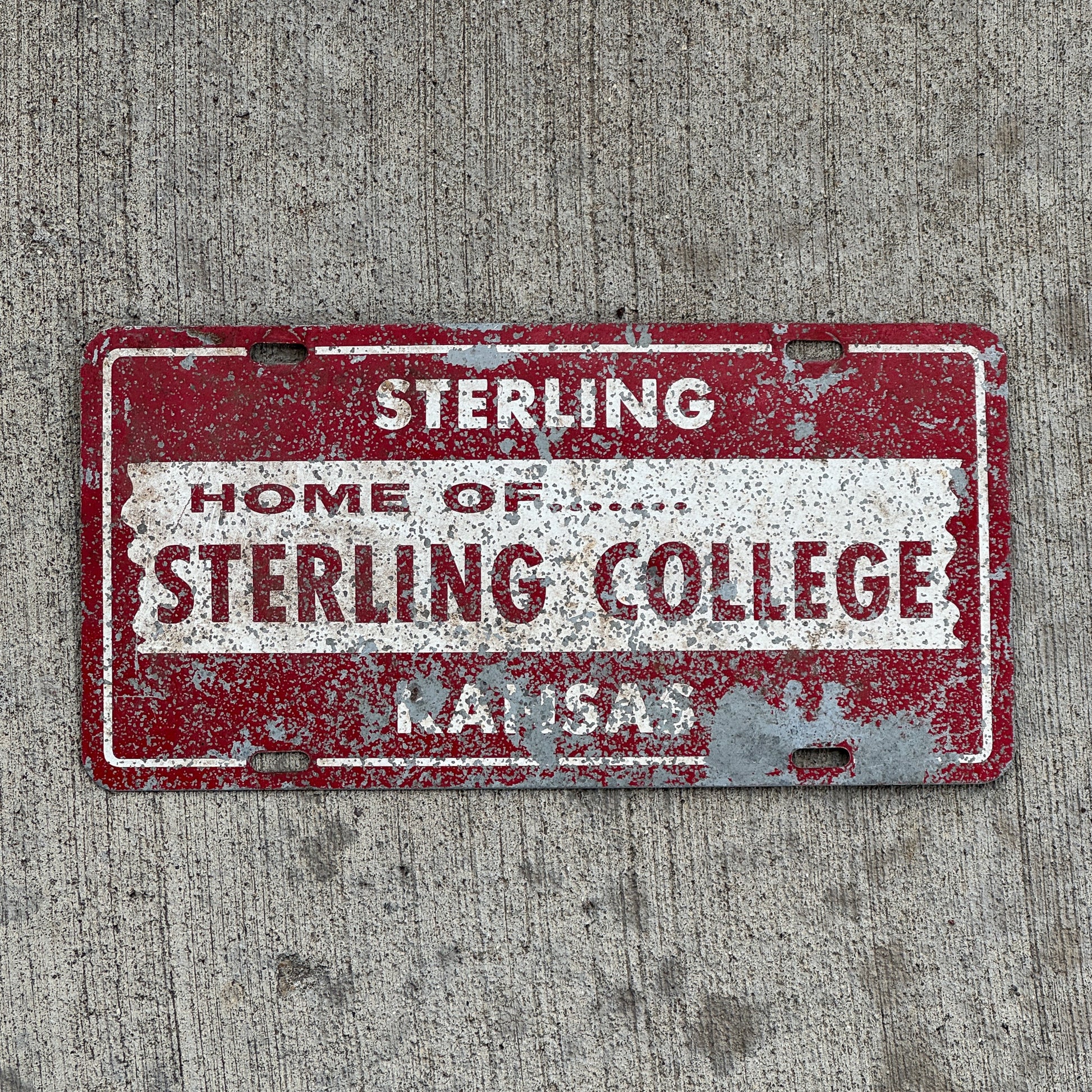 Photo of a 1970 Era Sterling College Kansas Booster License Plate Auto Tag Garage Decor Vintage with original patina