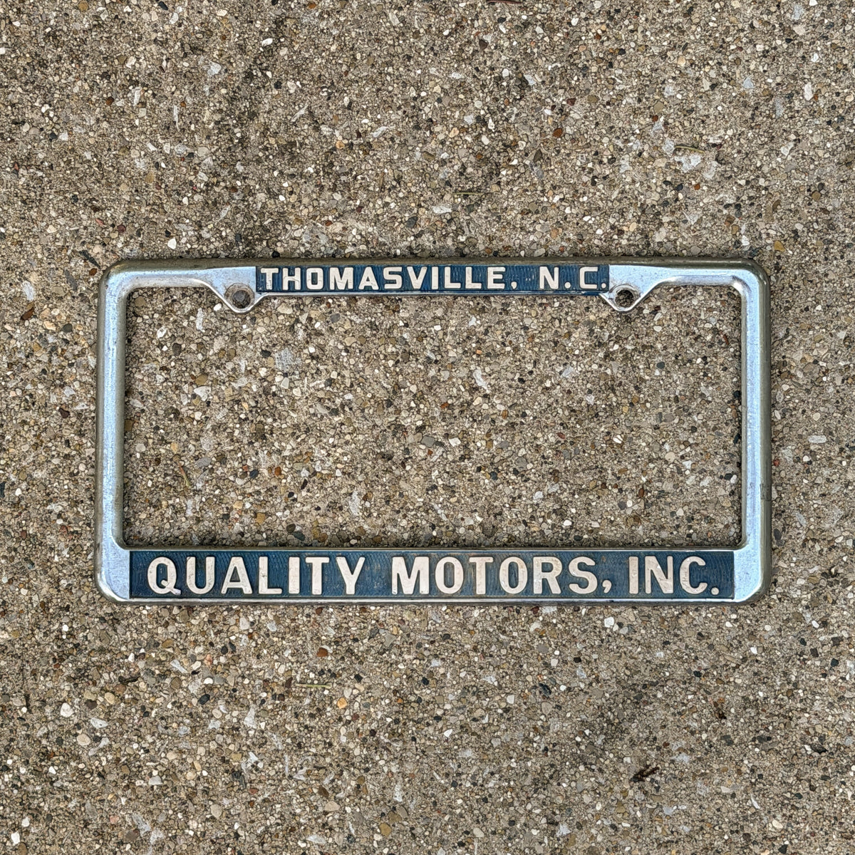 Photo of a 1970 Era Thomasville North Carolina License Plate Frame Auto Tag Garage Decor Vintage Quality Motors Inc. Metal with original patina