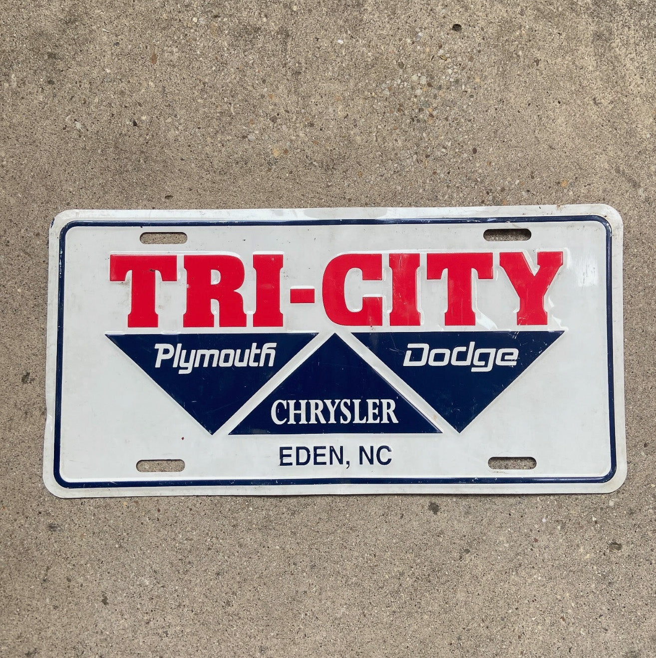 Photo of a 1970 Era Tri City Dodge North Carolina Booster License Plate Auto Tag Garage Decor Vintage Dealer Eden North Carolina with original patina