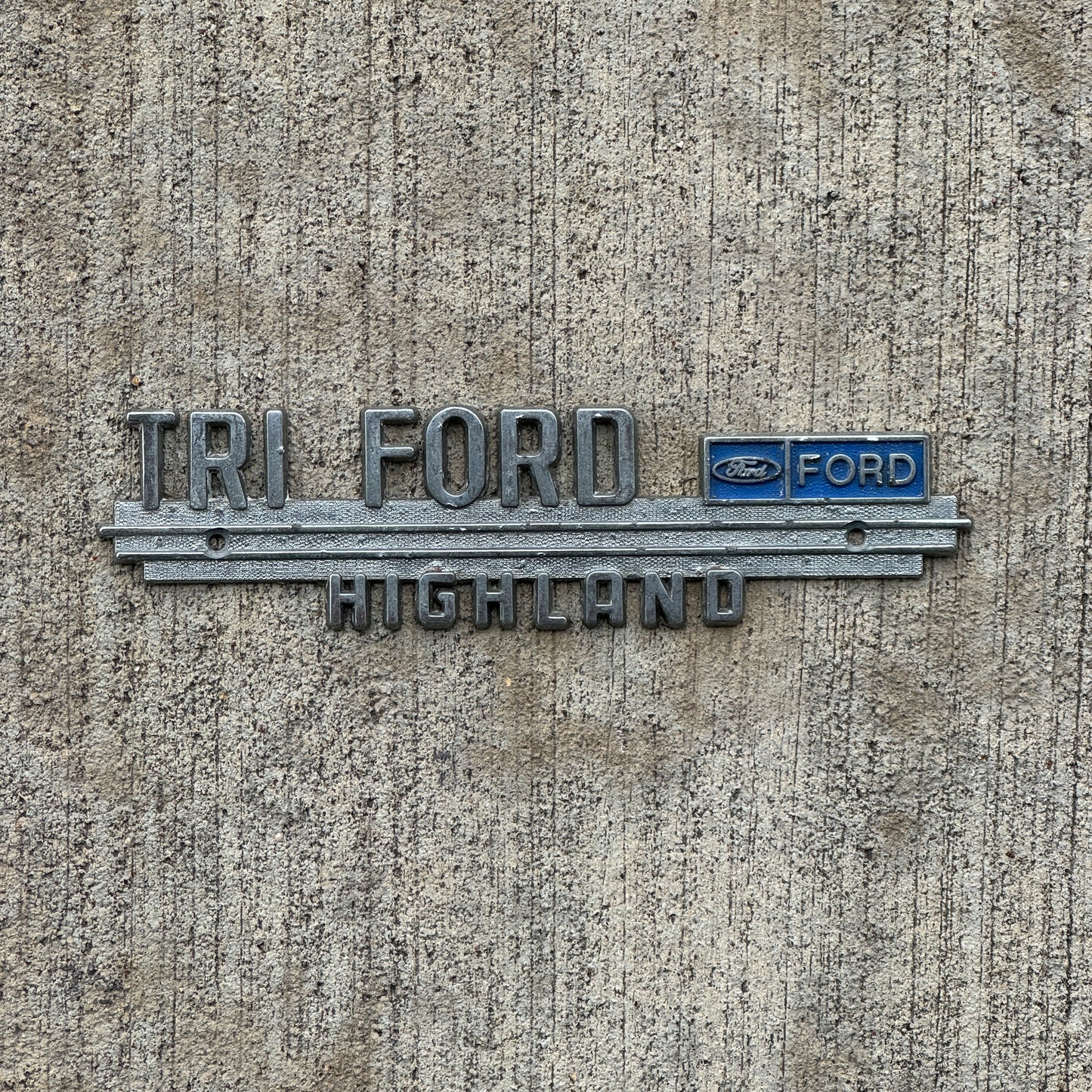 Photo of a 1970 Era Tri Ford Highland Illinois Dealer Badge Emblem Auto Tag Garage Decor Vintage Dealership with original patina