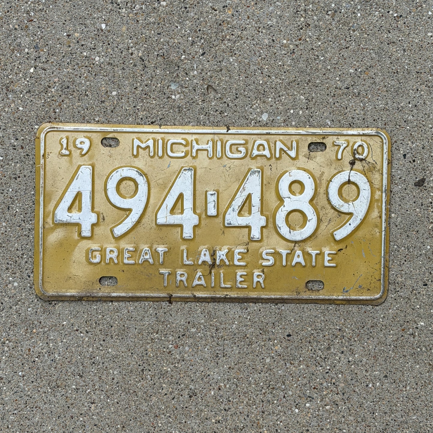 Photo of a 1970 Michigan Trailer License Plate Auto Tag Garage Decor Vintage 494 489 with original patina
