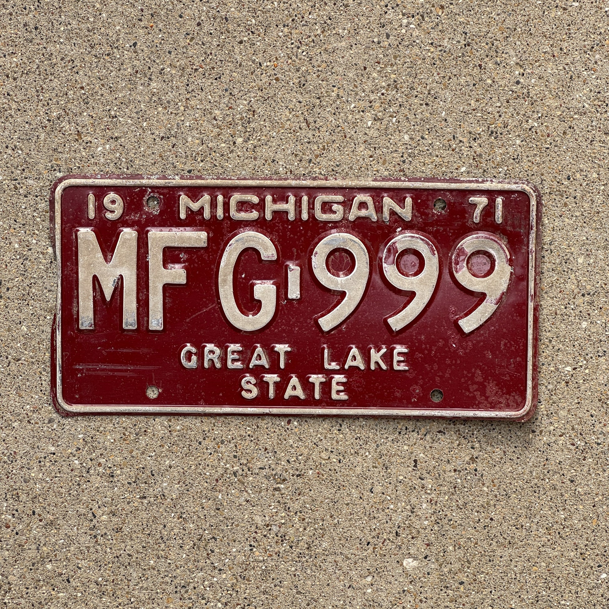 Photo of a 1971 Michigan License Plate Auto Tag 1 Vintage Garage Repeat Repeating MFG 999 with original patina